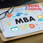 Indian student researching questions before online MBA on a laptop, analyzing accreditation, specialization options, course cost, flexibility, and career support